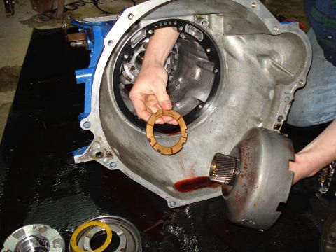 1984 Ford Bronco - A person is holding a transmission clutch pack disc while working on a transmission.