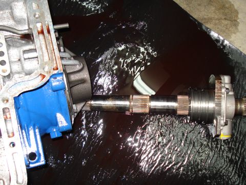 1984 Ford Bronco - Transmission pump and shaft submerged in dark fluid, with "SUPERMOTORS" visible in the lower right corner.