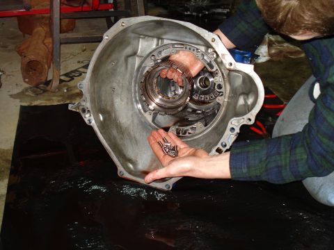 1984 Ford Bronco - Mechanic holding small metal components during a transmission rebuild.