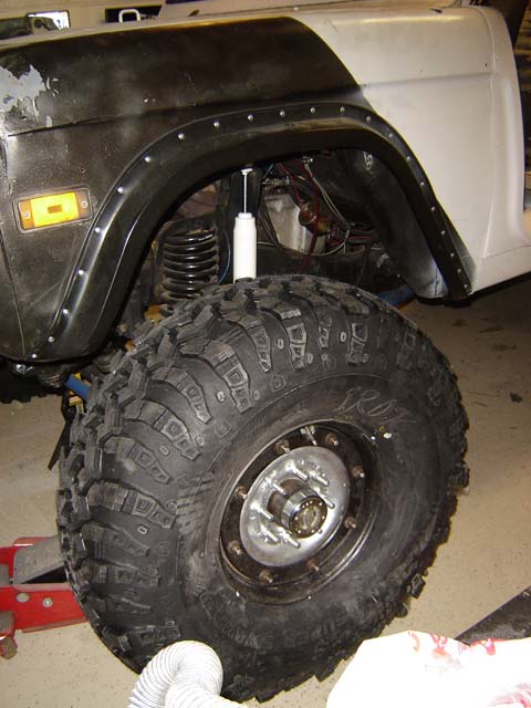 1971 Ford Bronco - Close-up of a 1971 Ford Bronco's fender and tire, showing off-road modifications.