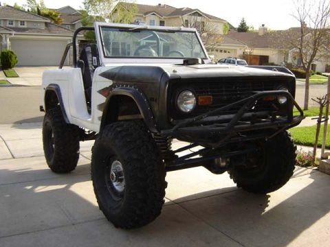 1971 Ford Bronco - This modified SUV features oversized tires and a prominent front brush guard, suggesting off-road use.