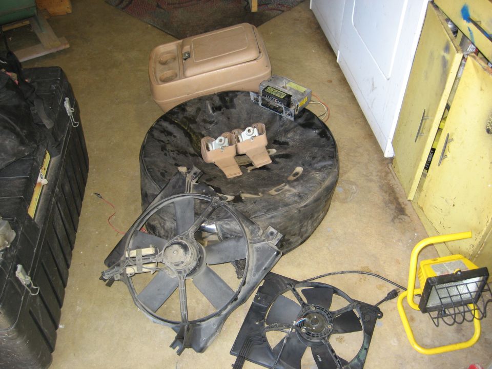 Spare tire with two mounting brackets, two radiator fans, and a center console storage unit