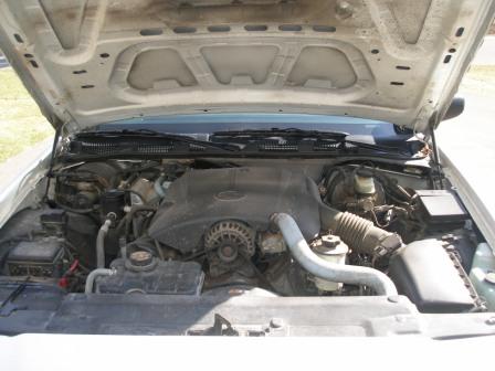 2000 Ford Crown Victoria - The engine compartment of a 2000 Ford Crown Victoria is shown with the hood raised.
