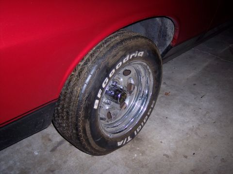 1972 Ford Ranchero - A close-up shot focuses on the tire and wheel assembly of a red vehicle.