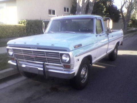 1969 Ford F-250 - A two-tone Ford pickup truck is parked on a residential street.