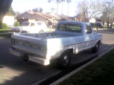 1969 Ford F-250 - A two-tone Ford F-250 pickup truck is parked curbside on a sunny day.