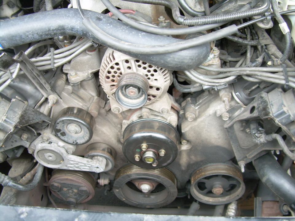 Close-up of engine pulleys, alternator, and water pump assembly