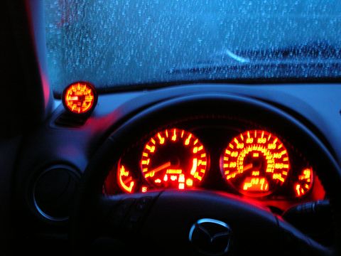 1994 Ford Probe - The illuminated dashboard gauges glow red at night, with rain visible on the windshield.