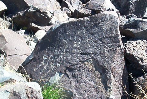 1986 Ford Bronco - A large rock with ancient carvings is seen in a rocky outdoor environment.