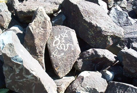 1986 Ford Bronco - A collection of rocks, one of which has white markings that resemble numbers and symbols etched into its surface.