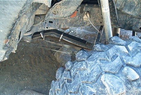 1986 Ford Bronco - This image shows the undercarriage of a vehicle, focusing on the suspension and a large tire.