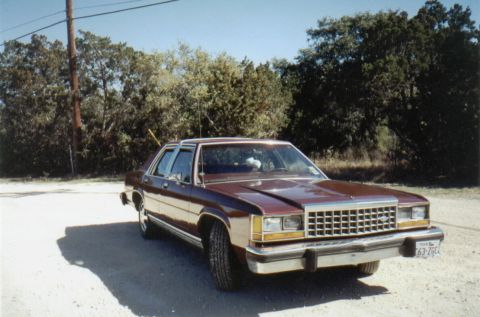 1986 Ford Crown Victoria LTD - This 1986 Ford LTD Crown Victoria is parked on a dirt road, with trees and a utility pole visible.