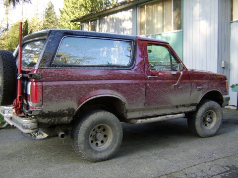 1989 Ford Bronco - This 1989 Ford Bronco is covered in mud, showing its off-road capabilities.