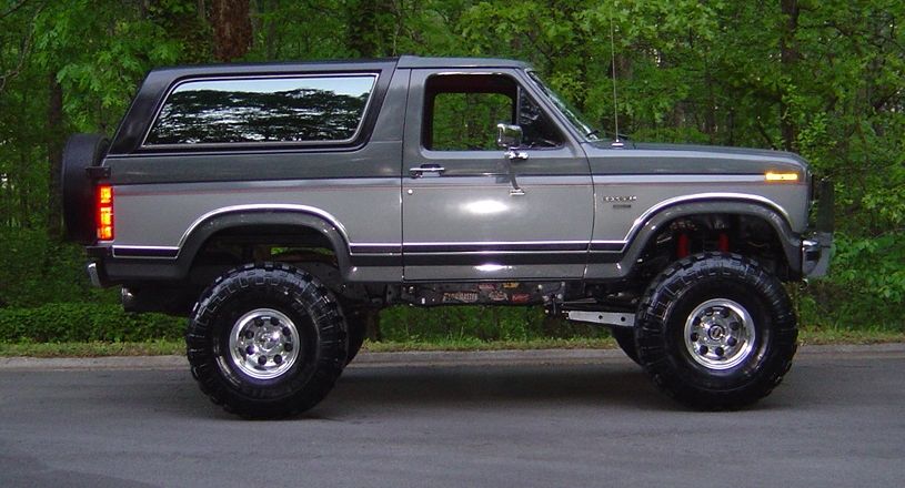Side view of lifted two-tone gray Ford Bronco SUV on big off-road tires