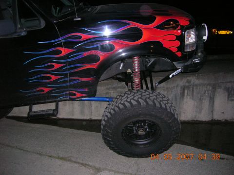 1996 Ford Bronco - This lifted Ford Bronco features custom flame decals and aggressive off-road tires.