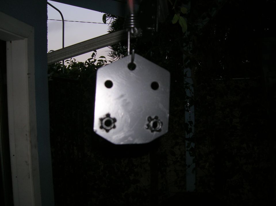 Metal bracket plate hanging outdoors at dusk