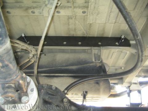 1987 Suzuki Samurai - Close-up of the underbody, focusing on the fuel tank and suspension system with an added bracket.