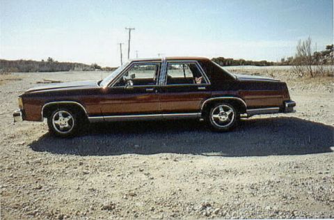 1986 Ford Crown Victoria LTD - Side view of a 1986 Ford Crown Victoria LTD sedan in a rural setting.