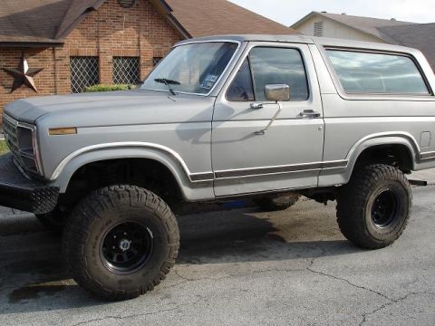1986 Ford Bronco - This lifted Ford Bronco features off-road tires and a silver paint job.