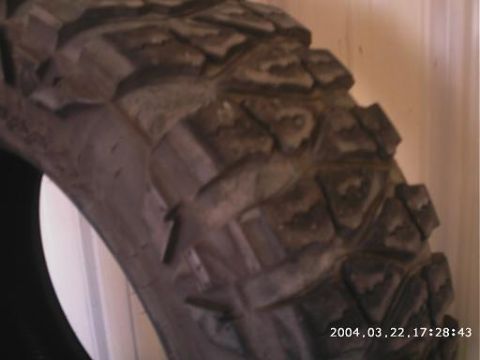 1986 Ford Bronco - A close-up view of a tire tread, showing its aggressive pattern and signs of use.