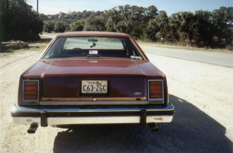 1986 Ford Crown Victoria LTD - This maroon sedan has a Texas license plate and a Ford emblem on the trunk.
