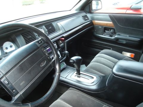 1992 Ford Crown Victoria - Interior of a Mercury sedan showing the dashboard, leather steering wheel with airbag, column shifter, woodgrain trim and cloth seats.