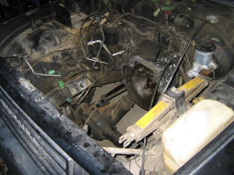 1987 Suzuki Samurai - The engine bay is exposed, with the transmission removed and various engine components visible.