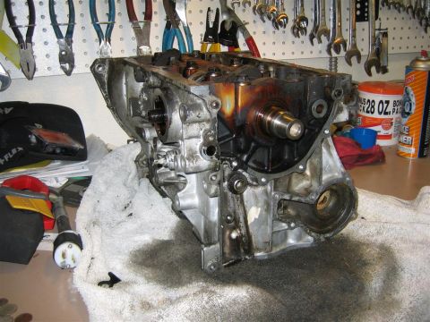 1987 Suzuki Samurai - Engine block disassembled and resting on a towel, surrounded by tools and automotive fluids.