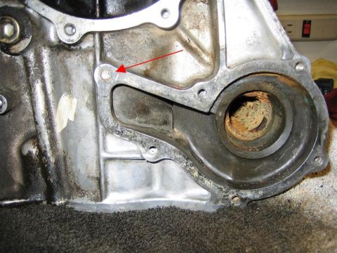 1987 Suzuki Samurai - Close-up of an engine block part, with a red arrow indicating a specific bolt hole.