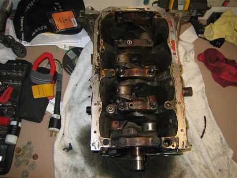 1987 Suzuki Samurai - Disassembled engine block with crankshaft and connecting rods exposed, surrounded by tools and shop rags.