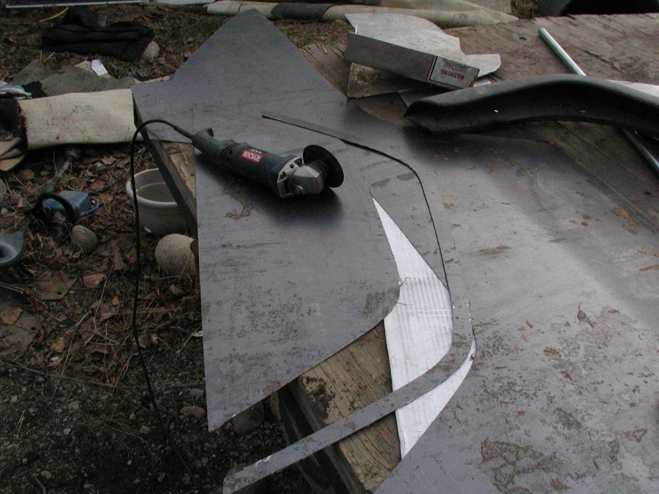 Metal sheets and a Ryobi angle grinder on a workbench