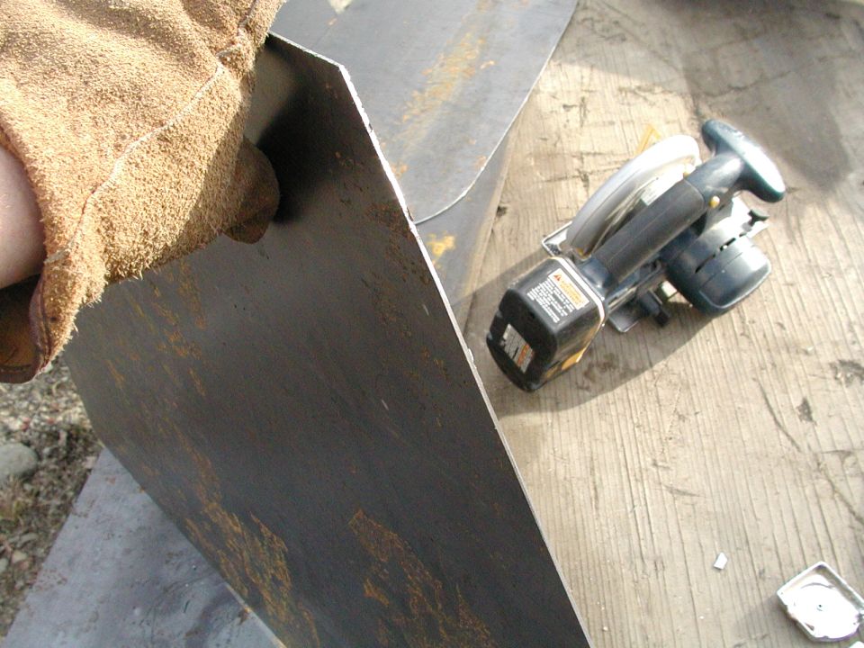 Metal sheet being cut by a circular saw on a wooden surface