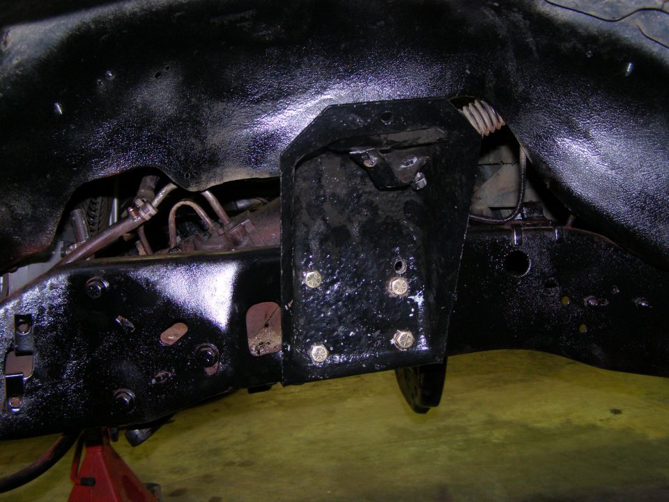 Close-up of vehicle frame with suspension bracket and bolts