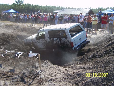 1989 Ford Bronco - A white SUV navigates a challenging mud pit during an event on March 18, 2007.