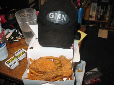 1997 Ford Crown Victoria - A meal of fried chicken and fries sits on a table next to a baseball cap and a glass of water.