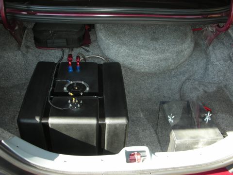 1992 Ford Crown Victoria - The trunk of a vehicle modified with a custom fuel cell and spare tire well, suggesting performance upgrades.