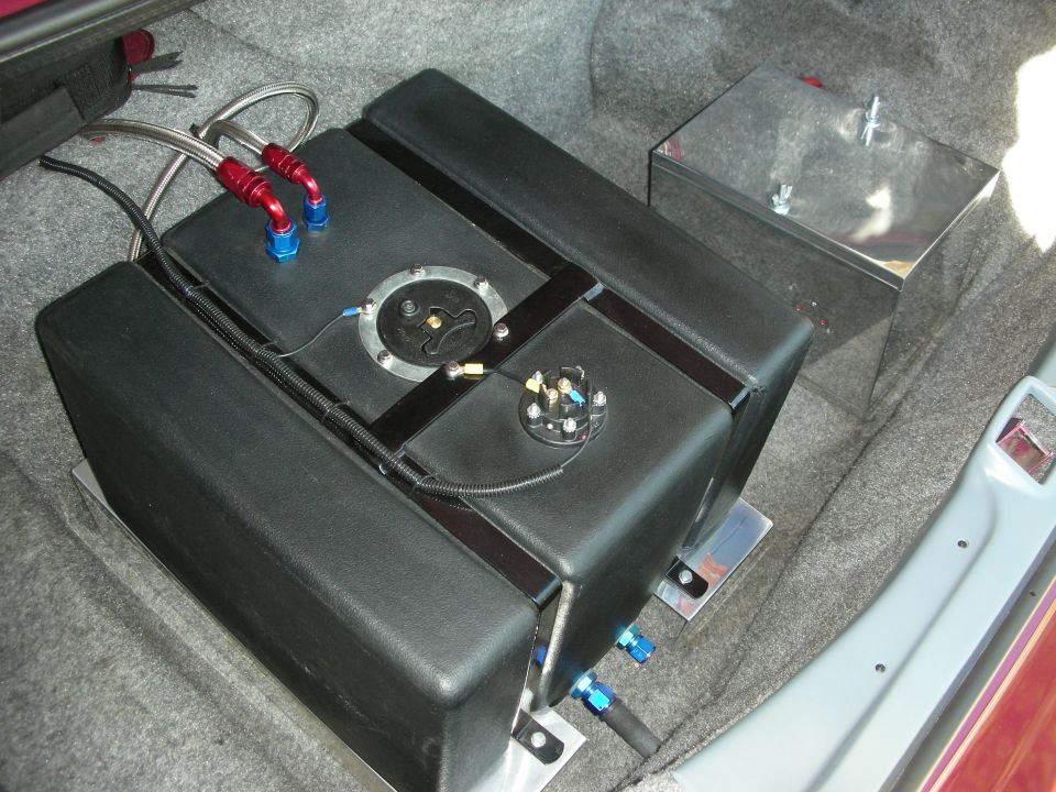 Aftermarket fuel tank and fuel cell with braided lines installed in a car's trunk