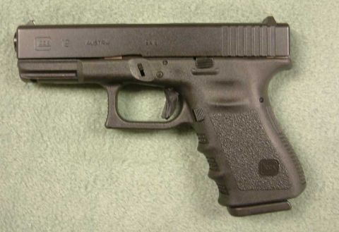 1991 Ford Bronco - A black Glock 19 pistol is shown from the side, with Austrian manufacturing marks visible on the slide.