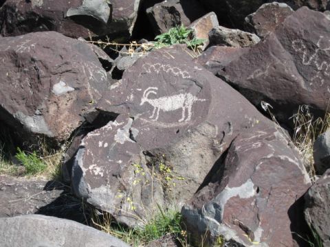 1997 Chevrolet C/K Pickup - Ancient petroglyphs are etched into dark rocks, depicting animal figures.