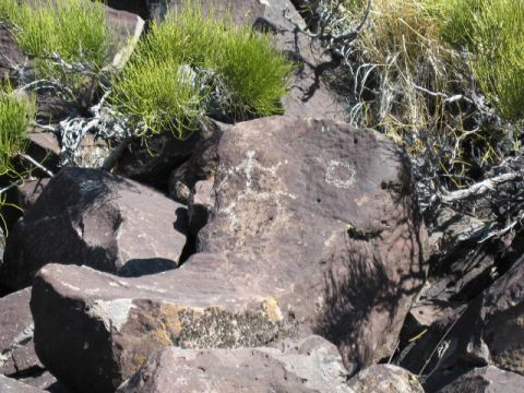 1997 Chevrolet C/K Pickup - Ancient carvings are etched into the surface of large rocks, surrounded by sparse vegetation and shadows.