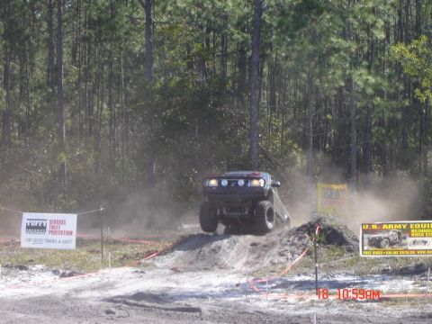1989 Ford Bronco - An off-road vehicle navigates a dirt track during an event.