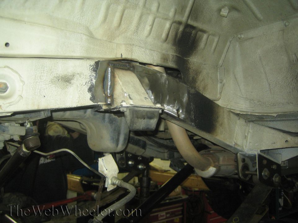 Close-up of a vehicle's frame showing recent welds and modifications to the suspension mounting points