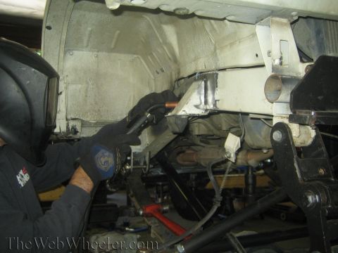 1987 Suzuki Samurai - Welding is being performed on the undercarriage of a vehicle that is supported by jack stands.