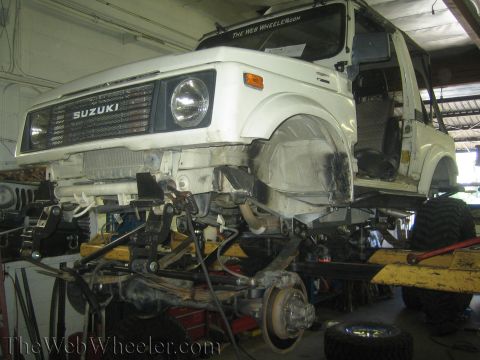 1987 Suzuki Samurai - This 1987 Suzuki Samurai is undergoing a shock swap, with its front end lifted and suspension components exposed for modification.
