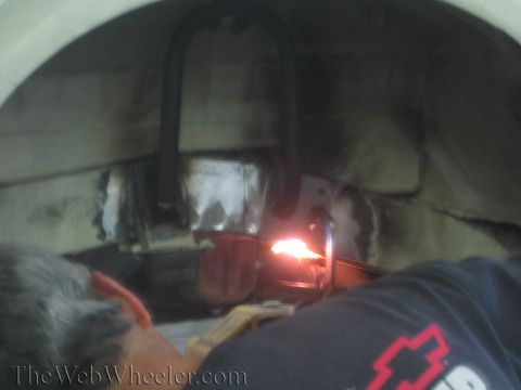 1987 Suzuki Samurai - A person welds a part of a vehicle's undercarriage, with bright sparks illuminating the scene.
