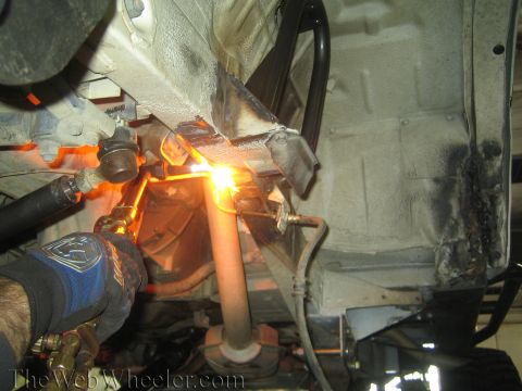 1987 Suzuki Samurai - A person is welding on the frame of a vehicle, likely modifying the suspension.