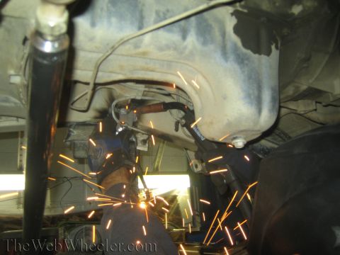 1987 Suzuki Samurai - Welding sparks illuminate the undercarriage of a vehicle during a shock swap modification.
