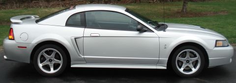 1998 Ford Taurus - This silver coupe features a rear spoiler and distinctive five-spoke wheels, suggesting a 1999 model year.