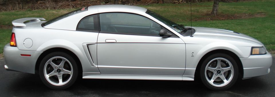 Silver coupe side view with spoiler and five-spoke wheels
