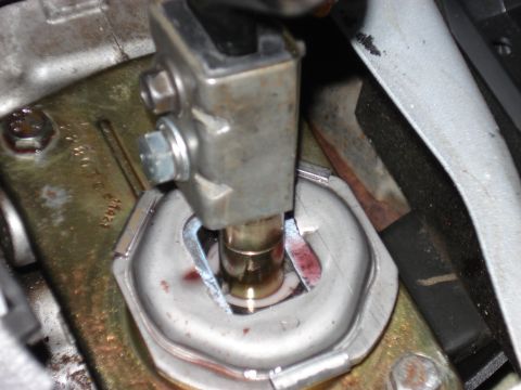 1998 Ford Taurus - Close-up view of a vehicle's shifter linkage mechanism, showing metal components and some red fluid.